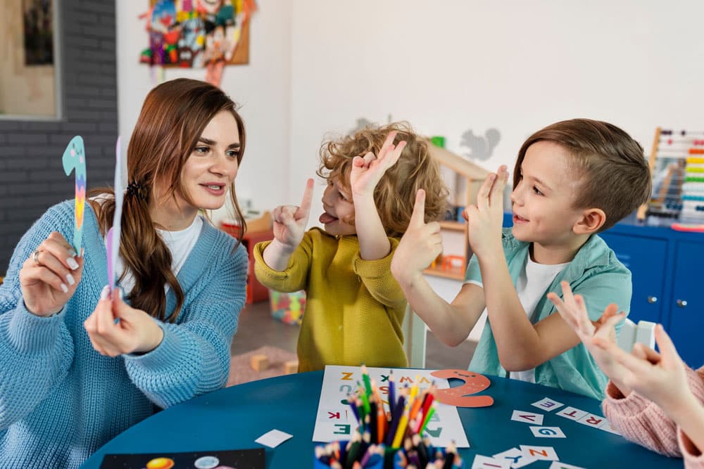 medium-shot-kids-teacher-table medium-shot-kids-teacher-table